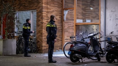 agenten bekijken schade aan gebouw na explosie