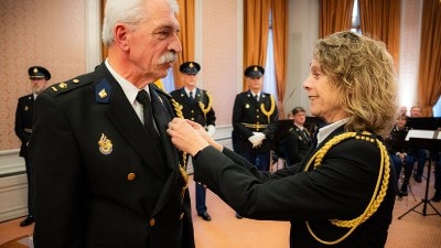 Een van de gelauwerden krijgt de eremedaille voor verdienste opgespeld door korpschef Janny Knol.