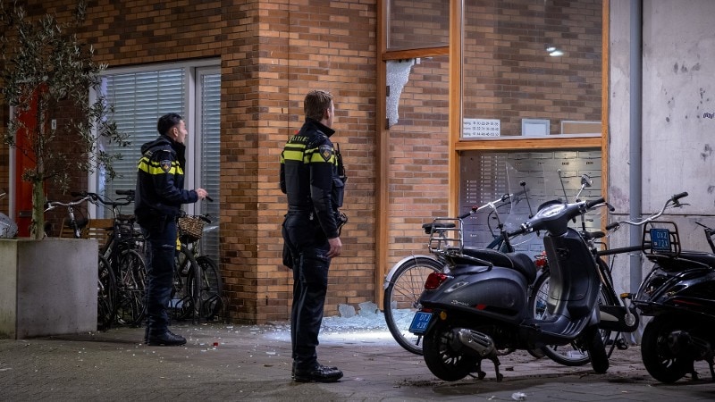 agenten bekijken schade aan gebouw na explosie