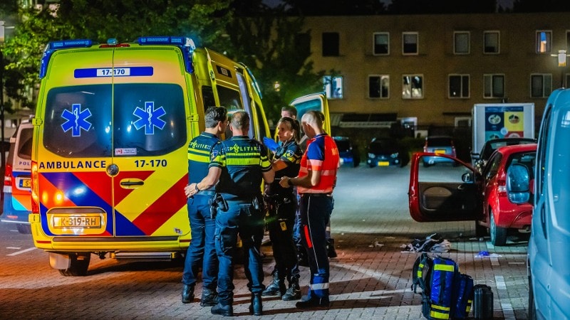 Ambulance in straat met politie en verpleegkundigen erbij