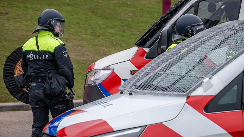 Stockfoto van een lid van de mobiele eenheid bij een aantal politievoertuigen